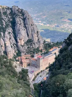 a building on a mountain next to a cliff at Casa acogedora al pie de Montserrat in Collbató