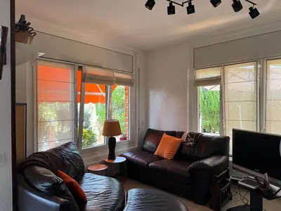 a living room with a leather couch and windows at Casa acogedora al pie de Montserrat in Collbató