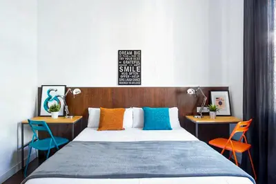 a bedroom with a bed with two tables and two chairs at Traveller House in Barcelona