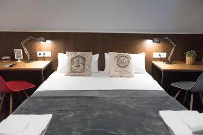 a bedroom with a bed with two tables and two chairs at Traveller House in Barcelona