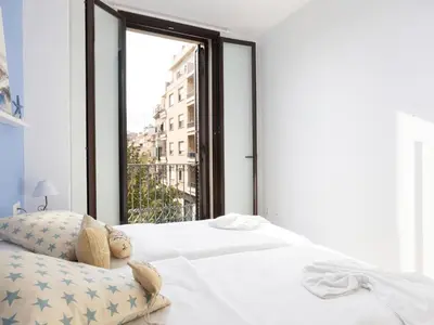 a bedroom with a white bed and a window at Matarolux23 in Mataró