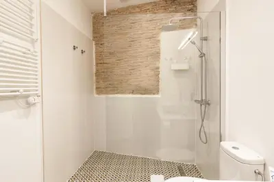 a white bathroom with a shower and a toilet at Bellafila Gothic Terrace in Barcelona