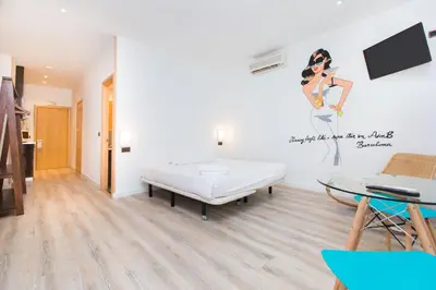 a bedroom with a bed and a painting of a woman on the wall at Cathedral Apartments in Barcelona