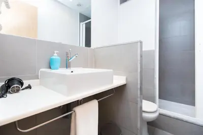 a bathroom with a sink and a toilet and a mirror at Cathedral Apartments in Barcelona