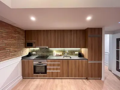 a kitchen with wooden cabinets and a sink at Passeig de Gràcia by Enjoybcn in Barcelona