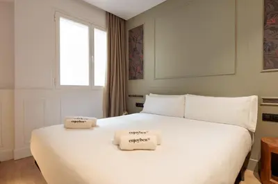 a bedroom with a large white bed with two towels on it at Passeig de Gràcia by Enjoybcn in Barcelona