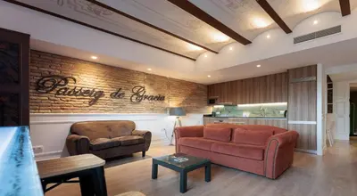 a living room with two chairs and a brick wall at Passeig de Gràcia by Enjoybcn in Barcelona