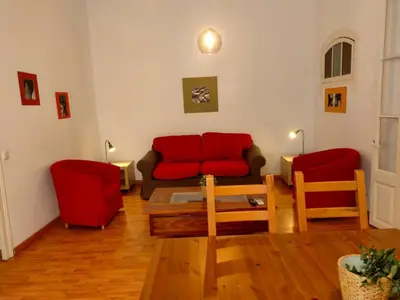 a living room with a couch and red chairs at Esparteria 1 in Barcelona