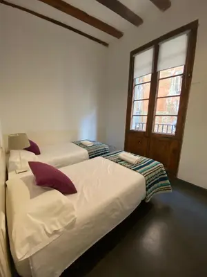 two beds in a room with two windows at Esparteria 2 in Barcelona