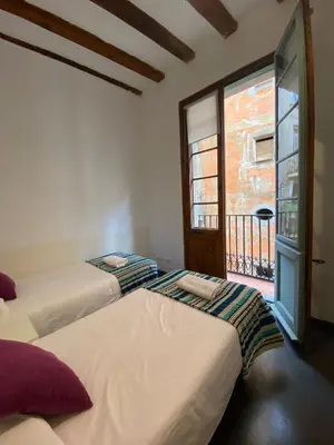 two beds in a room with a window at Esparteria 2 in Barcelona