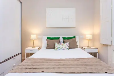 a bedroom with a large white bed with two lamps at Stay U-nique Apartments Floridablanca II in Barcelona