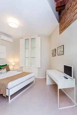 a bedroom with a bed and a desk with a television at Stay U-nique Apartments Floridablanca II in Barcelona