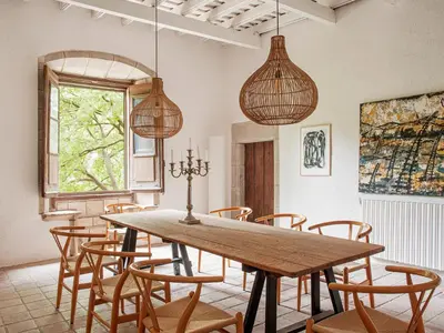 a dining room with a wooden table and chairs at Les Canes in Aiguafreda