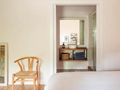 a bedroom with a bed and a chair and a mirror at Les Canes in Aiguafreda