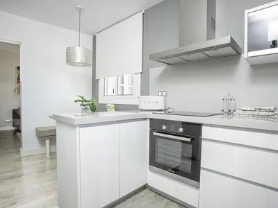 a kitchen with white cabinets and a stove at Sitges Spaces Bonaire Penthouse in Sitges