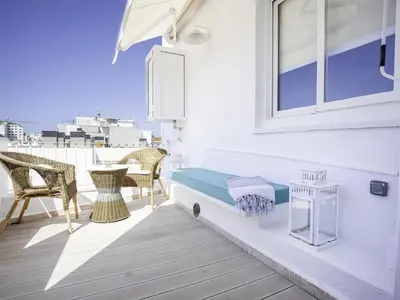 a balcony with a bench and chairs and a window at Sitges Spaces Bonaire Penthouse in Sitges
