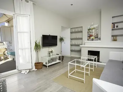 a white living room with a tv and a fireplace at Sitges Spaces Bonaire Penthouse in Sitges