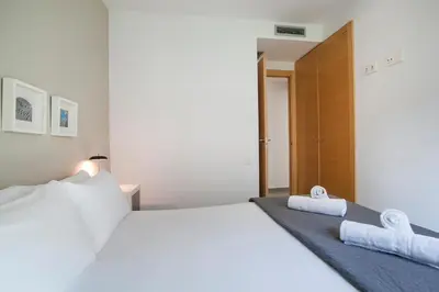 a bedroom with a large white bed with towels on it at BBarcelona Gaudí Flats in Barcelona