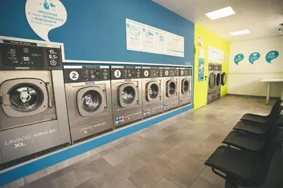 a row of washing machines in a laundry room at Tres Estrellas Barcelona by HolaCamp in Gavà