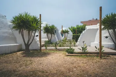 a garden with palm trees and a slide at Tres Estrellas Barcelona by HolaCamp in Gavà