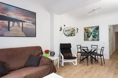 a living room with a couch and a table and chairs at Sagrada Familia Butterfly in Barcelona
