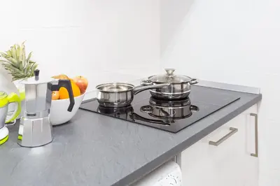 a kitchen counter with two pots and pans on a stove at Sagrada Familia Butterfly in Barcelona