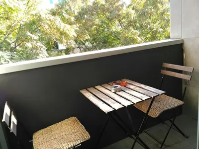 a table and two chairs on a balcony with a window at 2 BEDROOMS and 2 BATHROOMS FOR 5 PAX, SWIMMING POOL, FREE PARKING and NEAR THE BEACH! in Sant Adria de Besos