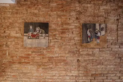 a brick wall with pictures of children and a toy car at Petit Luxe St. Pere in Terrassa