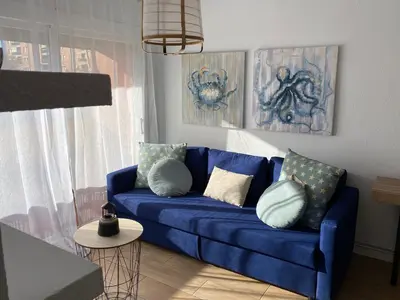 a blue couch with pillows in a living room at Vilamarlux VI in Vilassar de Mar