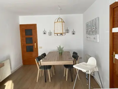 a dining room with a wooden table and chairs at Vilamarlux VI in Vilassar de Mar
