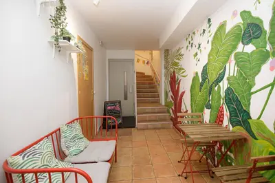 a hallway with chairs and a table and a mural at Onefam Batlló in Barcelona