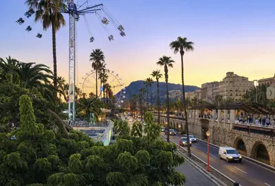 a city street with palm trees and a ferris wheel at Colom Apartment 3BR with Balcony & Port Vell Views in Barcelona