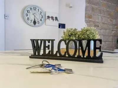 a sign that says welcome with a pair of keys at Colom Apartment 3BR with Balcony & Port Vell Views in Barcelona
