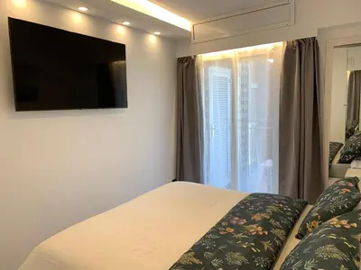 a bedroom with a bed and a window with a television at Formentor in Castelldefels