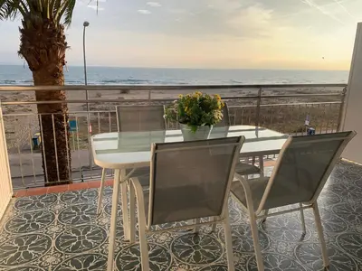 a table and chairs on a balcony with the ocean at Formentor in Castelldefels