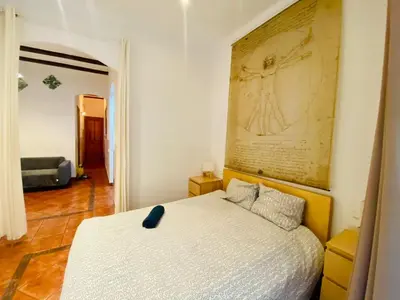 a bedroom with a bed with a painting on the wall at 03 cozy barça 2,1 in Barcelona