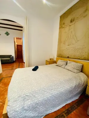 a bedroom with a white bed with a painting on the wall at 03 cozy barça 2,1 in Barcelona