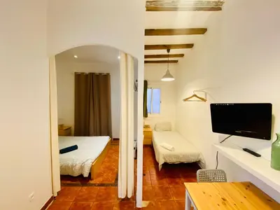 a small room with a bedroom with a bed and a tv at 03 cozy barça 2,1 in Barcelona