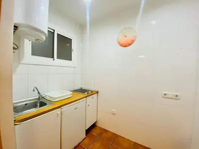 a kitchen with a sink and a clock on the wall at 03 cozy barça 2,1 in Barcelona
