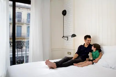 a man and a woman sitting on a bed at Praktik Bakery in Barcelona