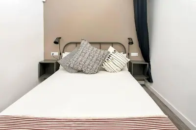 a bedroom with a white bed with pillows on it at Cozy&new With Terrace in Hospitalet de Llobregat