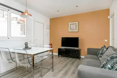 a living room with a table and a tv at Cozy&new With Terrace in Hospitalet de Llobregat