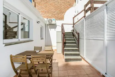 a dining room with a table and chairs and stairs at Cozy&new With Terrace in Hospitalet de Llobregat