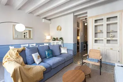 a living room with a blue couch and a chair at Apartamento Clsico Con Terraza in Barcelona