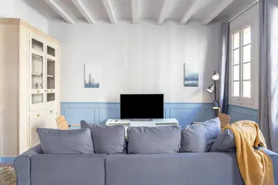 a living room with a blue couch and a television at Apartamento Clsico Con Terraza in Barcelona