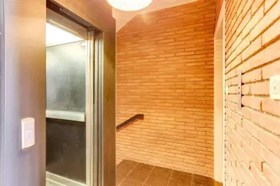 a bathroom with a walk in shower next to a brick wall at Colorful With Cozy Terrace In Gracia in Barcelona
