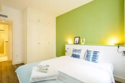 a bedroom with a large white bed with towels on it at Colorful With Cozy Terrace In Gracia in Barcelona
