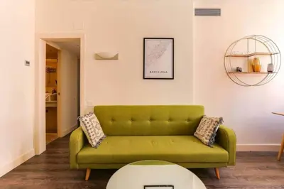 a living room with a green couch and a table at Stylish 2 Bdr In Trendy Gracia in Barcelona