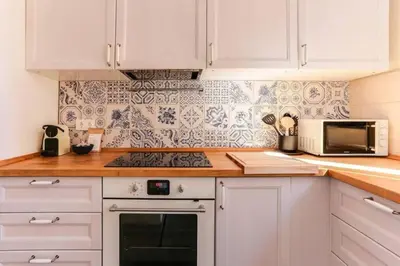 a kitchen with white cabinets and a stove top oven at Stylish 2 Bdr In Trendy Gracia in Barcelona