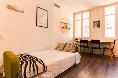 a bedroom with a bed and a table with chairs at Stylish 2 Bdr In Trendy Gracia in Barcelona